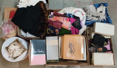 une boîte remplie de vêtements et d'autres objets posée par terre