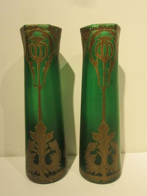 two green vases with gold designs on them