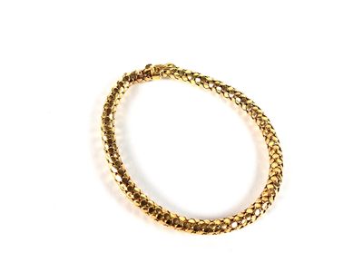 a close up of a gold bracelet on a white surface