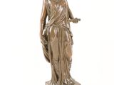 bronze statue of a woman holding a basket on a marble base