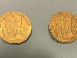 two pieces of gold coins sitting on top of a table