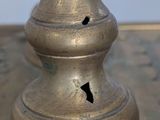 a close up of a metal vase with a hole in it