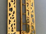 a close up of a gold buckle on a gray surface