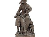 statue représentant une femme avec des enfants et un chien, posée sur un socle en pierre