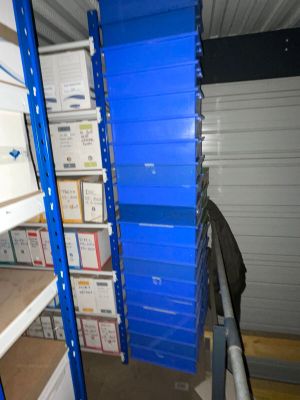 a blue shelf with boxes on it in a storage room