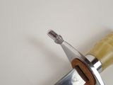 a close up of a knife on a white surface
