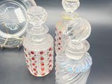 three glass bottles and a glass plate on a table