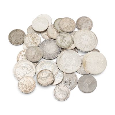 une pile de vieilles pièces d'argent sur une surface blanche