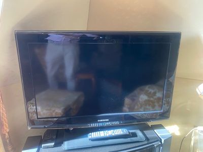 un téléviseur posé sur une table en verre