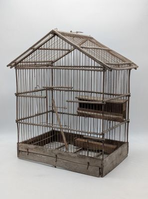 une cage à oiseaux contenant un oiseau, sur fond blanc