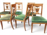 four chairs with green velvet upholstered seats and a wooden frame