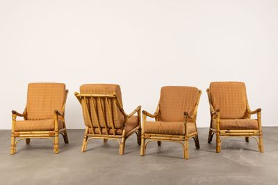 four chairs in a row in a room with a wall in the background