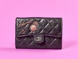 un gros plan d'un sac à main noir sur fond rose