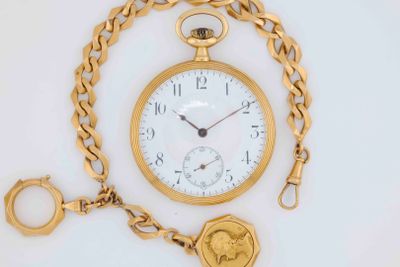 a gold pocket watch with a chain around it