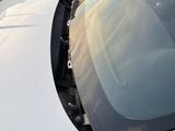 a white car with a broken windshield in a parking lot