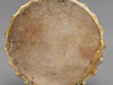 an image of a gold plate with a circular design on it