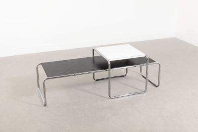 deux tables noires et blanches posées sur un sol en béton