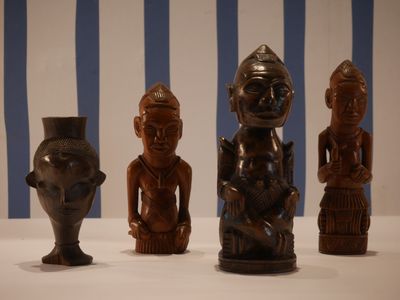 trois figurines en bois posées les unes à côté des autres sur une table