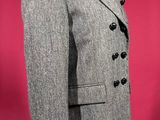 a suit on a mannequin stand against a red background