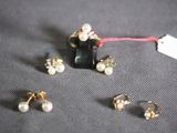 three pairs of earrings and a necklace on a table