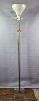 a floor lamp that is standing on a brick floor