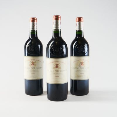 three bottles of red wine are lined up on a white surface