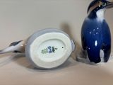 porcelain figurine of a blue bird and a white vase on a table