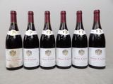six bouteilles de vin sont alignées sur une table