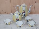 four cups and a teapot sitting on a table