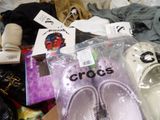 a pile of shoes and other items on a bed