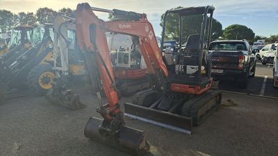a small excavator that is parked in a parking lot