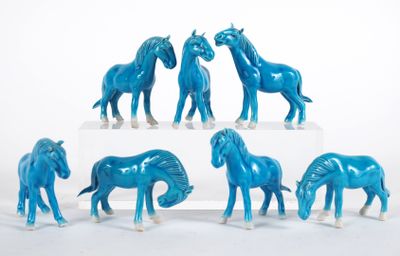 a group of blue horses standing on a white surface