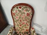 a chair with a floral upholstered back and arms