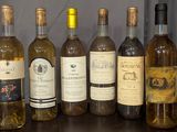 bottles of wine are lined up on a shelf in front of a wall