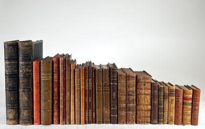 several old books stacked on top of each other on a white surface