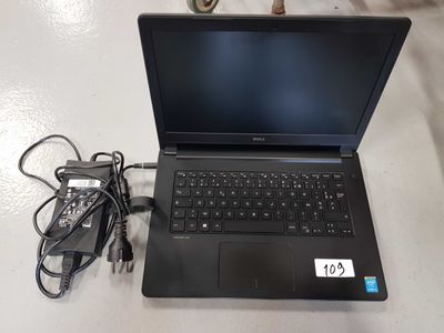 an open laptop computer sitting on top of a table next to a charger
