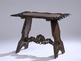 une table ancienne en bois, avec un plateau et des pieds sculptés