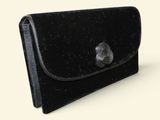 a black purse that is sitting on a white surface