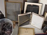a lot of picture frames and other items on a table