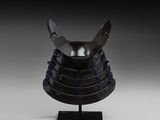 un casque posé sur un support, sur fond gris