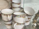de nombreuses tasses et soucoupes exposées dans une vitrine
