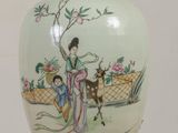 a vase with a painting on it sitting on a table