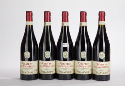 quatre bouteilles de vin sont alignées sur une surface blanche