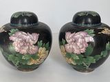 deux vases décorés de fleurs, posés sur une table