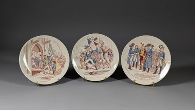 three plates with a painting of people on them sitting on a table