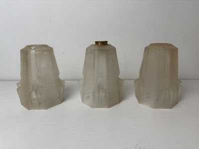 three white glass vases sitting on top of a white table