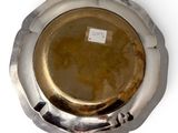 a silver plate with a tag on it on a white surface