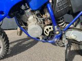a blue dirt bike parked in front of a building