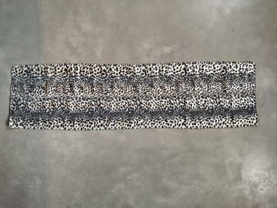 a black and white leopard print headband on a gray background
