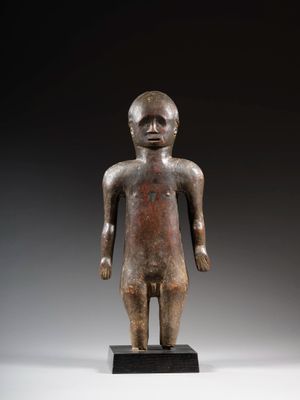 une statue en bronze représentant un homme debout sur un socle noir